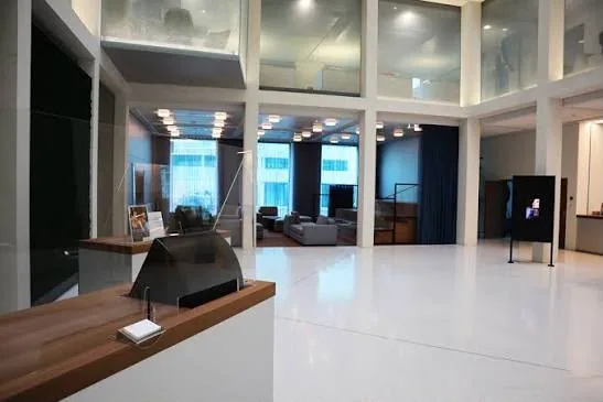 Espace de réception du Credit Suisse avec banque d'accueil en bois et plafonds blancs