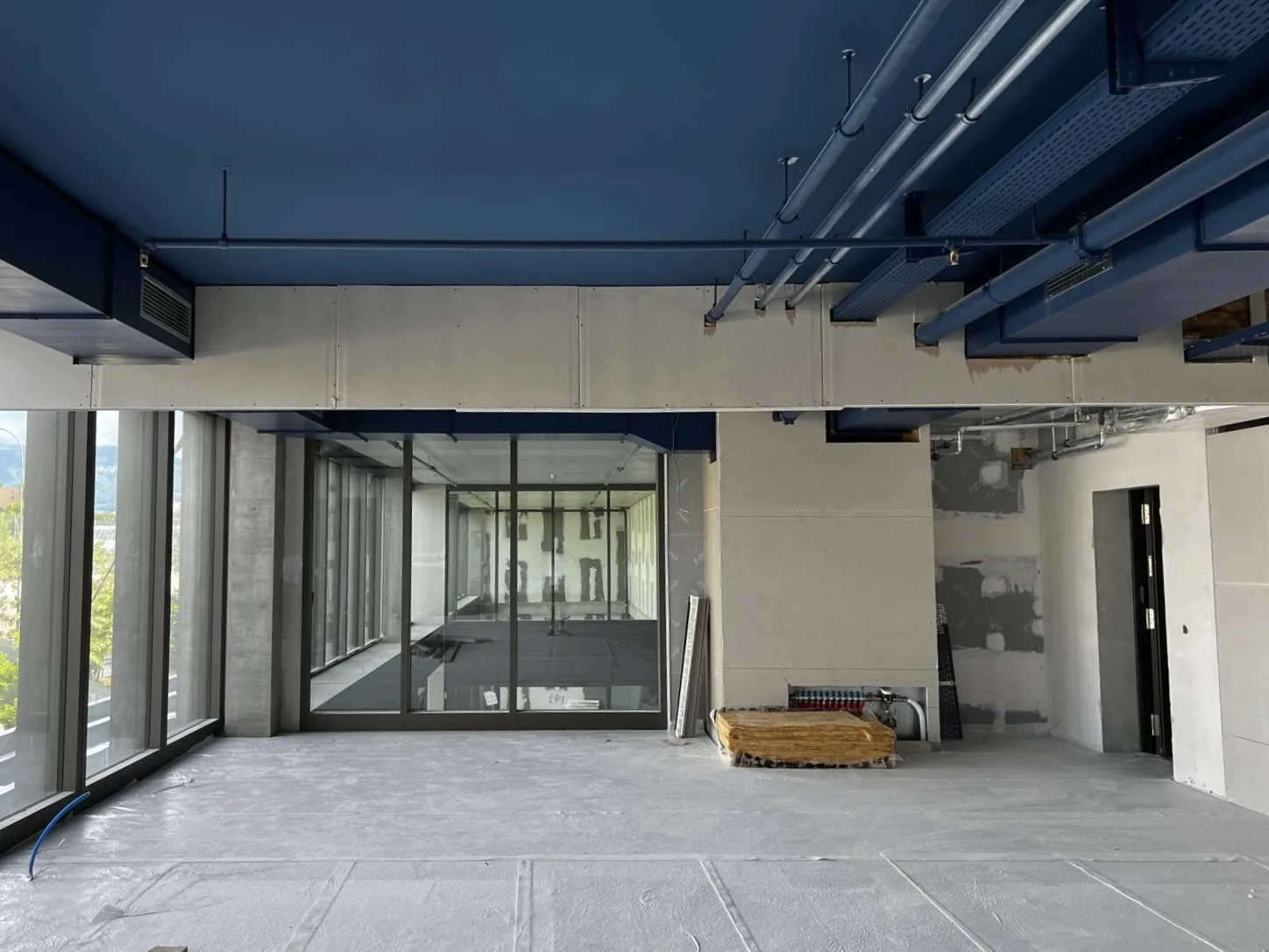 Plateau de bureaux OMS Genève en rénovation — plafond peint en bleu nuit et gaines apparentes